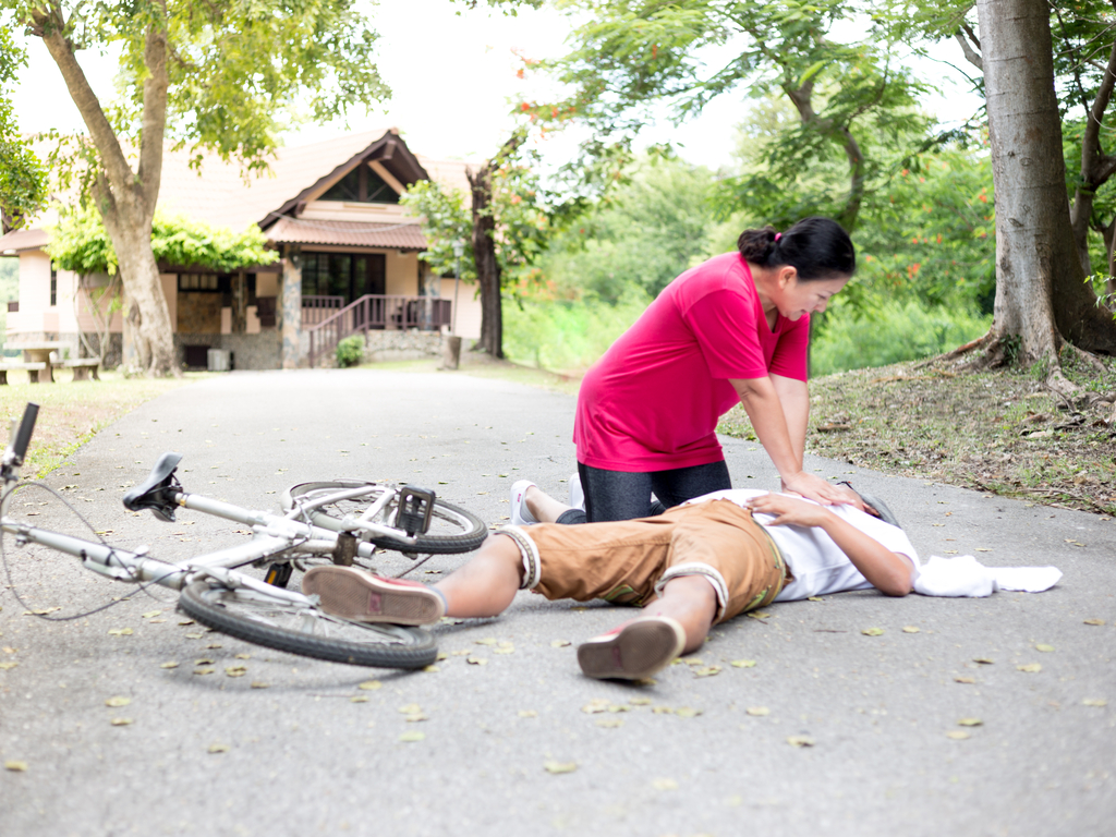 Bystander performing CPR on cyclist image